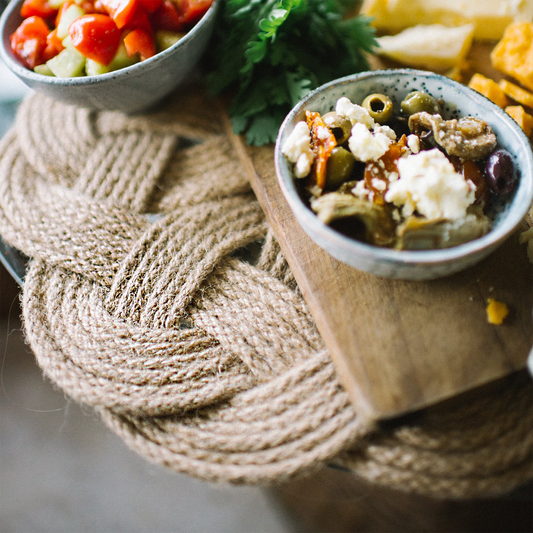 Mediterranean appetizers with olives, cheese, and salad in bowls on wooden board
